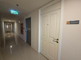 Hallway with numbered doors and emergency exit sign