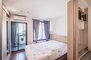 Bedroom with large bed, mirrored closet, and attached laundry room with washing machine