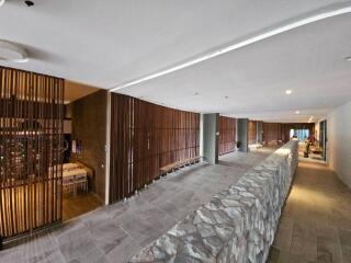 Large hallway with stone wall and wooden panel dividers