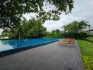 Outdoor pool area with wooden deck and lounging chairs