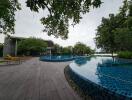 Outdoor pool area with wooden deck and lounge chairs