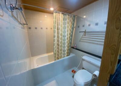 Bathroom with white tiles and bathtub