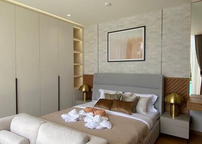 Modern bedroom with a large bed, built-in wardrobes, and decorative lighting