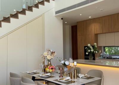 Modern dining area with a set table and an elegant staircase