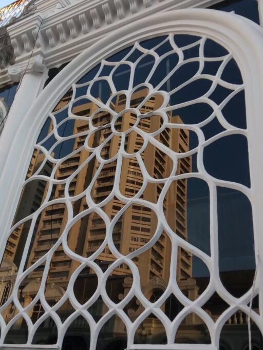 Ornate window with a reflection of a tall building