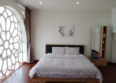 Spacious bedroom with large window and decorative wall art