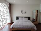 Spacious bedroom with large window and decorative wall art