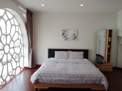 Spacious bedroom with large window and decorative wall art