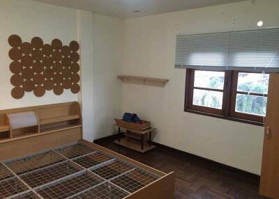 Empty bedroom with wooden bed frame and window