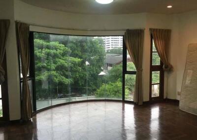 Spacious living room with large windows and wooden flooring