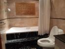 Bathroom with beige marble walls, black stone bathtub steps, and a modern toilet