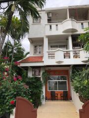 Front view of a multi-story residential building with a garden