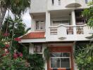 Front view of a multi-story residential building with a garden