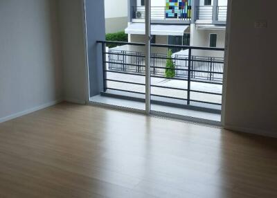 Bright, unfurnished living room with wooden floors and large window