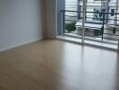 Empty bedroom with large window and balcony