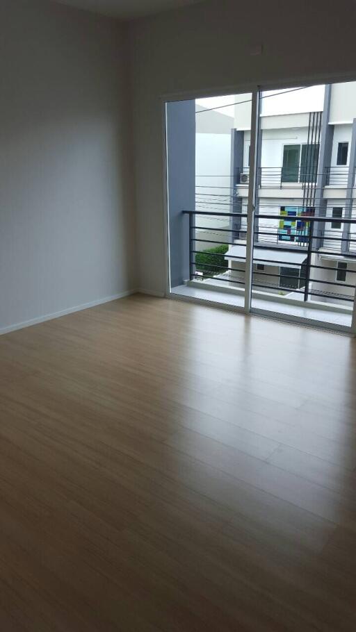 Empty bedroom with large window and balcony