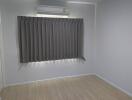 Bedroom with air conditioner and closed curtain