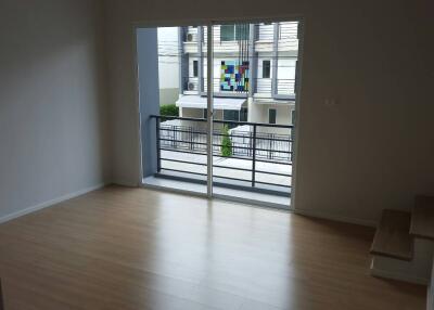 Unfurnished main living area with wooden flooring, sliding glass doors, and access to a balcony