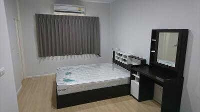 Modern bedroom with bed, dresser, and air conditioning