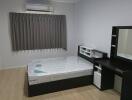 Modern bedroom with bed, dresser, and air conditioning