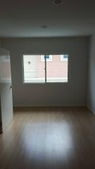 Empty bedroom with window and wooden floor