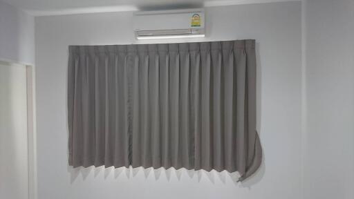 Bedroom with air conditioner and window with curtains