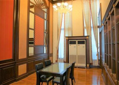 Dining room with high ceilings, chandelier, and large windows