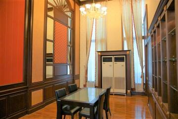 Dining room with high ceilings, chandelier, and large windows