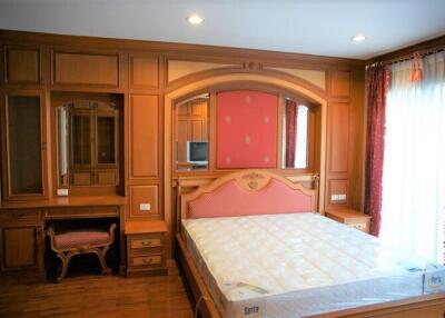 Spacious bedroom with wooden furniture and a large bed