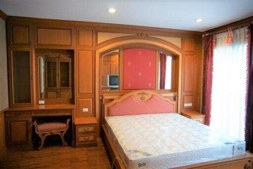 Spacious bedroom with wooden furniture and a large bed