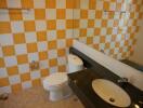 Bathroom with checkered yellow and white tile walls, dark countertop, and a large mirror