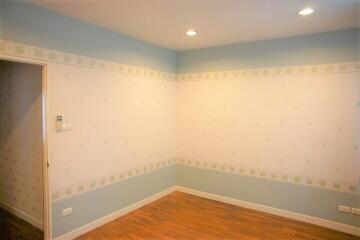 Spacious empty bedroom with light fixtures and wooden floor