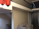 Living room with grey sofa, wooden floor, and red hanging lanterns