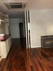 Living area with wooden flooring and partially brick-textured wall