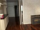 Living area with wooden flooring and partially brick-textured wall