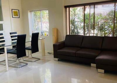 Modern living room with dining area, large windows, and minimalist decor