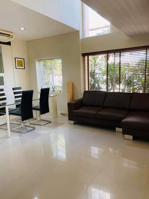 Modern living room with dining area, large windows, and minimalist decor