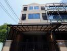 Modern multi-storey building exterior with gated entrance