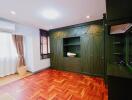 Spacious bedroom with built-in green wardrobes and parquet floors