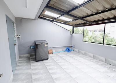 Bright utility area with washing machine and tiled flooring