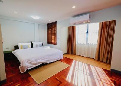 Modern bedroom with hardwood floor and large windows