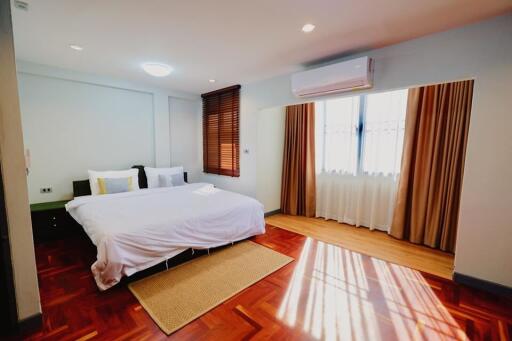 Modern bedroom with hardwood floor and large windows