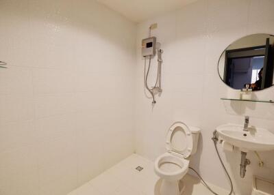 Minimalist bathroom with white tiles and basic fixtures