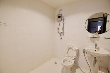 Minimalist bathroom with white tiles and basic fixtures