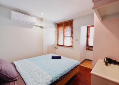 Bright and cozy bedroom with bed, window blinds, and air conditioning unit