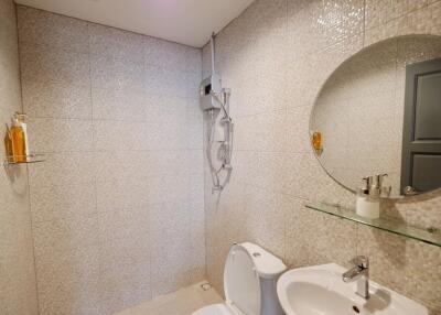 Modern bathroom with tiled walls, a toilet, and a sink