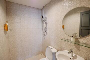 Modern bathroom with tiled walls, a toilet, and a sink