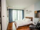 Contemporary bedroom with wooden flooring and large windows