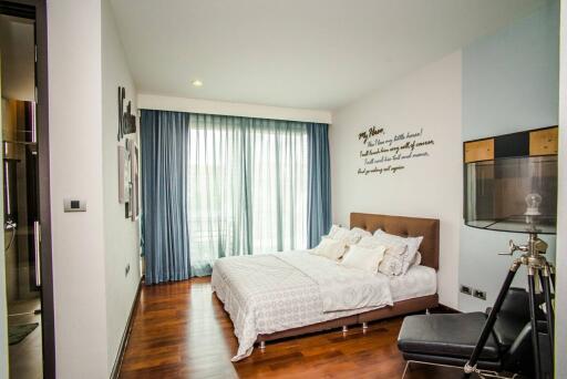 Contemporary bedroom with wooden flooring and large windows