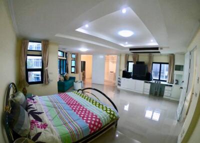 Spacious and modern bedroom with large windows, a comfortable bed, and a sitting area